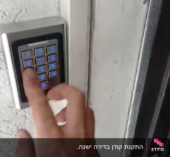 יד לוחצת על מקלדת כניסה לדלת
